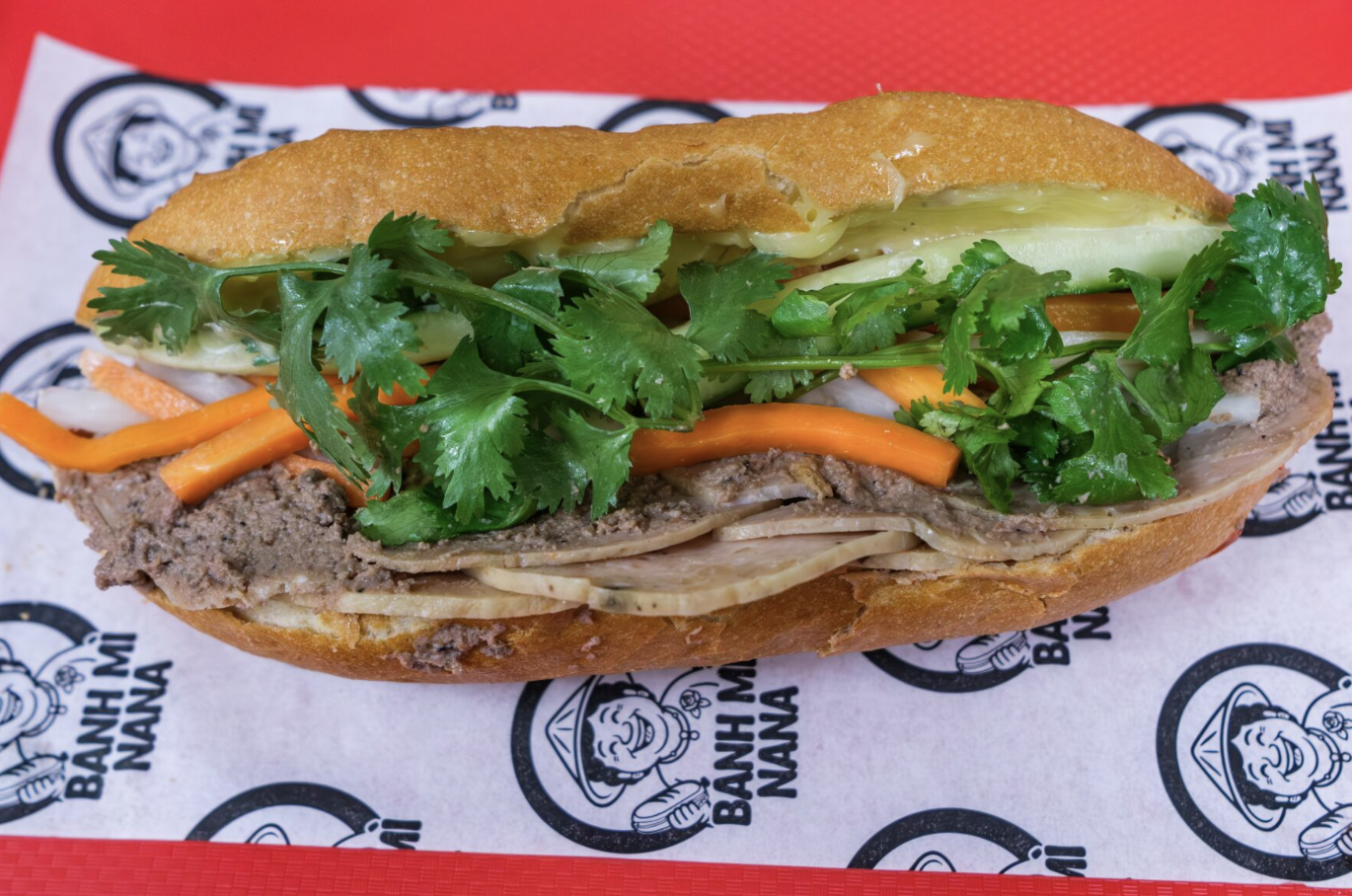 Bánh mì filled with meat, vegetables, and cilantro.